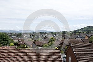 Roof tops of Abergele village in Britain with surrounding countryside, mountains, hills and blue sky and clouds 1 of 2