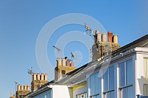 Roof tops with chimneys and TV aerials on terrace, row houses.