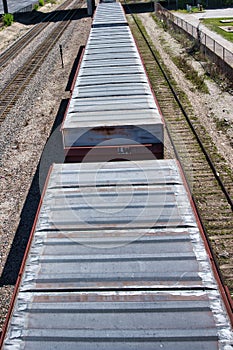 Roof tops of railroad box cars in a train - tracks, ties, gravel