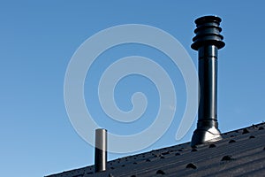 Roof with ventilation pipe and flue terminal photo