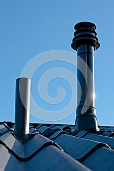 Roof with ventilation pipe and flue terminal