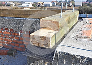 Roof wooden beams, trusses installation with bitumen membrane on brick house wall. Roofing Construction