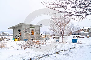 Roofed storage shed with single door on a landscape with snow at winter time