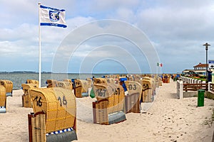 Roofed wicker beach chairs at beach of German village Laboe in summer