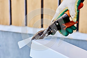 Roofer cuts roofing iron with sheet metal shears.