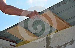 Roofer installing lightweight metal roofing sheets on new house rooftop. Lightweight metal roofing construction
