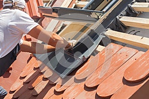 Roofer installs a skylight on the new roof. photo