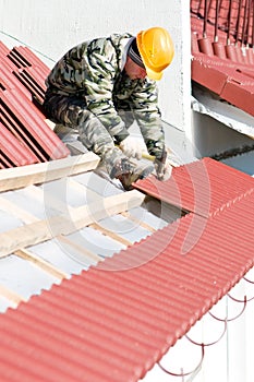 Roofer nailing clay tile