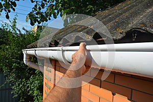 Roofer repair and renovate roof gutter on old brick house asbestos roof photo