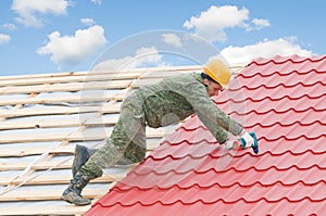 Roofer screwdriving metal tiling