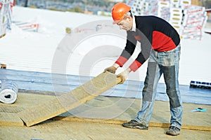 Roofer worker installing roof insulation material