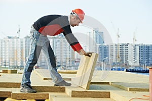 Roofer worker installing roof insulation material photo