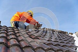 A Roofer working on roof structure of building on construction site,Roofer using air or pneumatic nail gun and installing Concrete