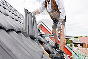 roofer working with tiles on the roof.