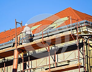 Roofer works on the roof of an old building