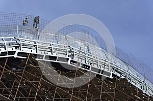 Roofers, tied with ropes working on the roof 4