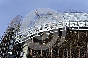 Roofers, tied with ropes working on the roof 6