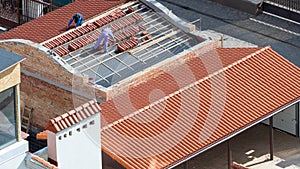 Roofers working on rooftop, install new tile