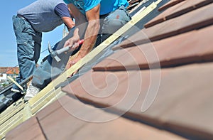 Roofers working at the top of a house