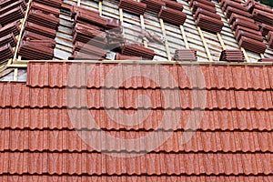 Roofing construction with clay roof tiles. Roofer laying ceramic roof tiles.