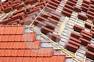 Roofing construction with clay roof tiles. Roofer laying ceramic roof tiles.