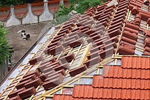 Roofing construction with clay roof tiles. Roofer laying ceramic roof tiles.