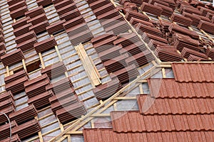 Roofing construction with clay roof tiles. Roofer laying ceramic roof tiles.