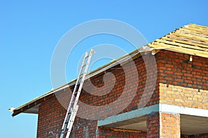 Roofing Construction. Roof-trusses. Wooden Roof Frame Unfinished House Construction with metal ladder.