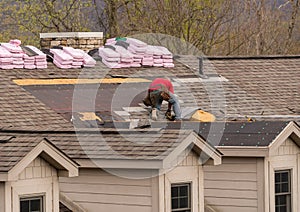 Roofing contractor removing the old shingles from a roof ready for reroofing