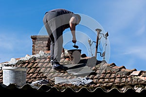 Roofing Repair: Skilled Craftsman Restoring a House with Tiles and Cement