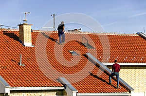 Roofing, repairing tiles on the roof of a building.