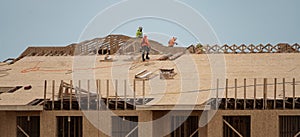 Roofing on roof. Builder roofer install new roof. Construction worker roofing on a large roof apartment building