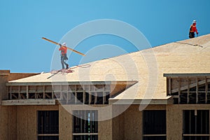 Roofing on rooftop. Builder roofer install new roof. Construction worker roofing on a large roof apartment building