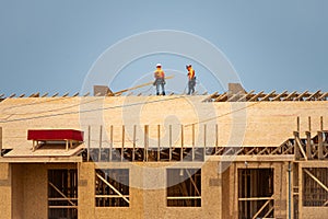 Roofing on rooftop. Builder roofer install new roof. Construction worker roofing on a large roof apartment building