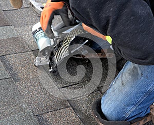 ROOFING WORK: professional roofer repairs shingles.