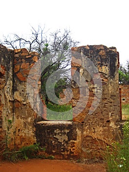 ROOFLESS STRUCTURES OF OLD RUINS OF A FORT WITH ENCROACHING VEGETATION photo