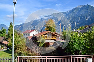 Roofs of beautiful houses in a village in the Alps in autumn with mountains in the background