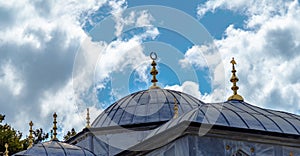 Roofs of a historic building in Turkey in front of a blue-white dramatic sky