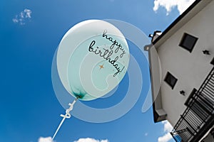 Roofs of houses. Air balloon on the background of the sky. Rise to the sky. Light, weightless. Holiday concept. Happy Birthday - photo