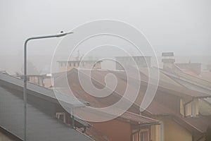 Roofs of houses in the fog. Residential buildings in a small city in a row