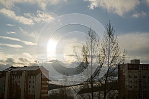 Roofs of houses, trees and fields covered by snow during winter.