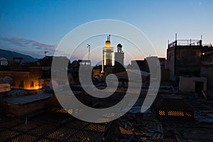 Roofs at Medina and Bou Inania mosque tower at blue hour, Medina of Fez, Morocco