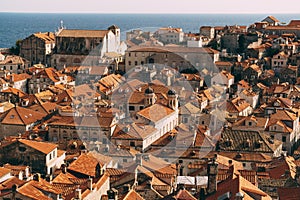 Roofs of the old city of Dubrovnik, orange roof tiles on houses, a view from a height, from the wall. Domes of The