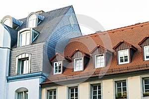 Roofs of old houses with roof windows and orange roof tiles in G