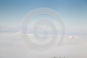 Roofs of several high rise buildings in the fog