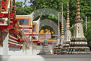 Roofs and stupas of famous ancient Reclining Gold Buddha Temple Wat Pho or Wat Phra Chetuphon with ornately carved traditional d