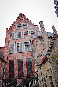Roofs And Windows Of Old Authentic Brick Houses And Church In Bruges, Belgium