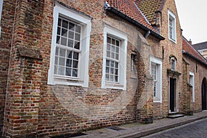 Roofs And Windows Of Old Authentic Brick Houses And Church In Bruges, Belgium