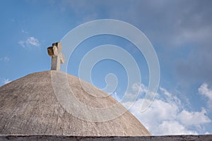 Rooftop dome of a greek church with christian cross symbol against blue sky