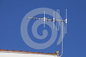 Rooftop television aerial against blue sky